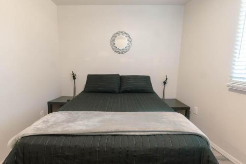a bed in a room with two tables and a mirror at Departamento Nuevo in Tijuana