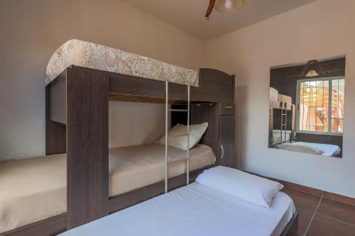 Un dormitorio con dos literas y un espejo. en Cabañas La Ernestina, en Villa Carlos Paz