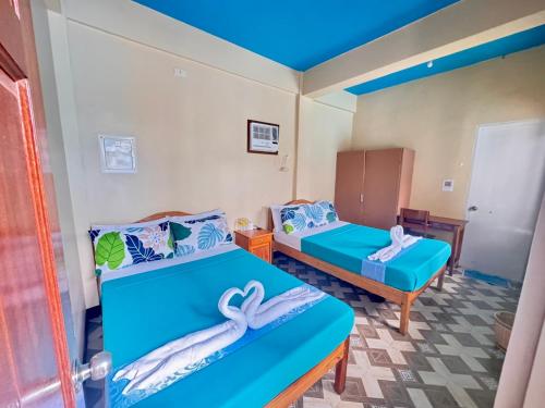 a room with two beds in a room at Mariner's Pension House in Puerto Princesa City