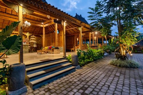 een houten paviljoen met een trap ervoor bij Taksu Sebatu Villa by Dhananjaya Hospitality in Ubud