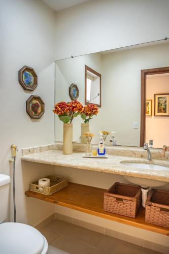 a bathroom with a sink and a mirror at Casa Cajueiro - Arraial Dajuda - limpeza diária inclusa no preço para sua maior comodidade - localização excepcional em frente ao Eco Parque e poucos passos da Praia dos Pescadores in Arraial d'Ajuda