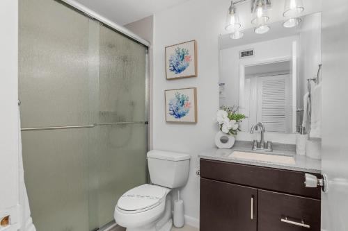 a bathroom with a shower and a toilet and a sink at The Naples Beach Retreat in Naples