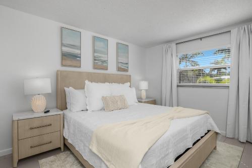 a bedroom with a large bed and a window at The Naples Beach Retreat in Naples