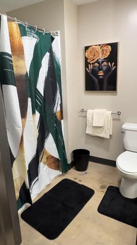 a bathroom with a shower curtain and a toilet at Opulent Oasis Located in The Heart of Birmingham in Birmingham