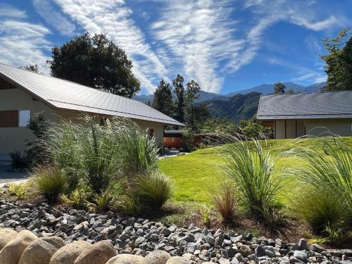 a house with a yard with grass and rocks at ヴィラグリファーム七里岩 in Nirasaki