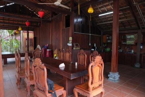 a dining room with a wooden table and chairs at Pun House in Phan Thiet