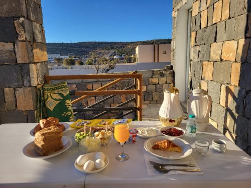 een tafel met eten en glazen sinaasappelsap bij Shahad Guest House in Jebel Shams