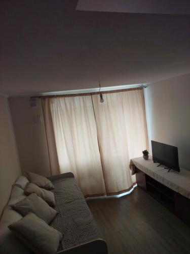 ein Wohnzimmer mit Sofa und Fernseher in der Unterkunft Departamento cerca de la Playa in La Serena