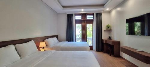 une chambre d'hôtel avec deux lits et une fenêtre dans l'établissement Tam Coc Vivana Hotel, à Ninh Binh