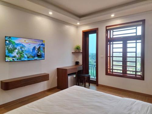 une chambre avec un lit, un bureau et une fenêtre dans l'établissement Tam Coc Vivana Hotel, à Ninh Binh