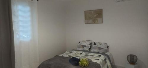 a bedroom with a bed and a picture on the wall at Éden Home Accès Rivière Privée in Goyave