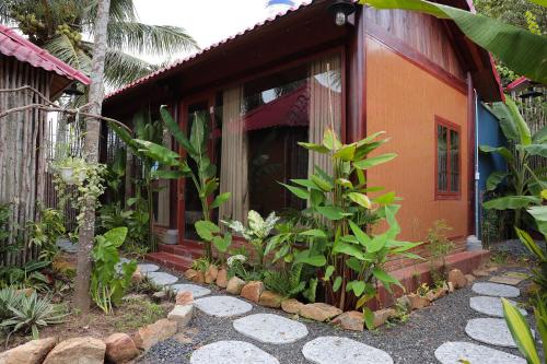 a small house with a garden in front of it at Pun House in Phan Thiet