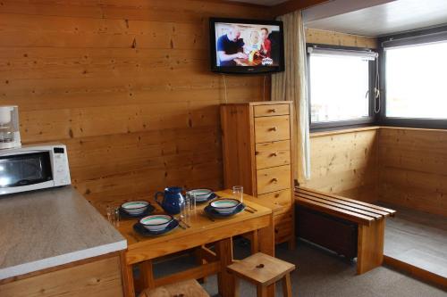 une petite cuisine avec une table et un micro-ondes dans l'établissement Névés Appartements VTI, à Val Thorens