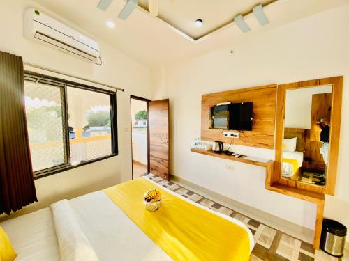 a bedroom with a large bed and a television at Hotel Vallabh at Pichola Lake Nathi Ghat Brahmpole Udaipur in Udaipur