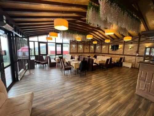 ein Esszimmer mit Tischen und Stühlen und Fenstern in der Unterkunft Zhaily Sai Resort, in Zhezdi