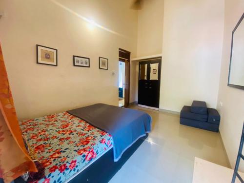カラングートにあるBaga Apartments Goaのベッドと青いソファのある寝室