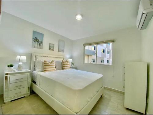 Un dormitorio con una cama blanca grande y una ventana en Vista Colonial, en Calero