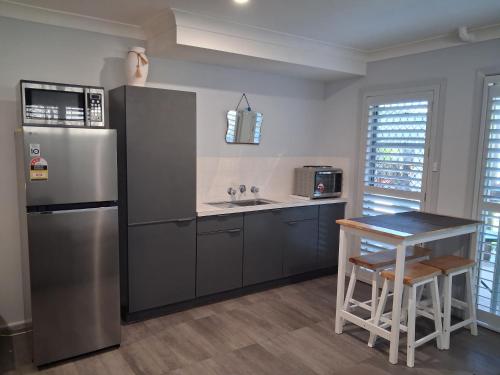 a kitchen with a stainless steel refrigerator and a table at Bonnys Bliss in Bonny Hills