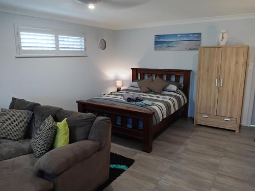 een woonkamer met een bed en een bank bij Bonnys Bliss in Bonny Hills