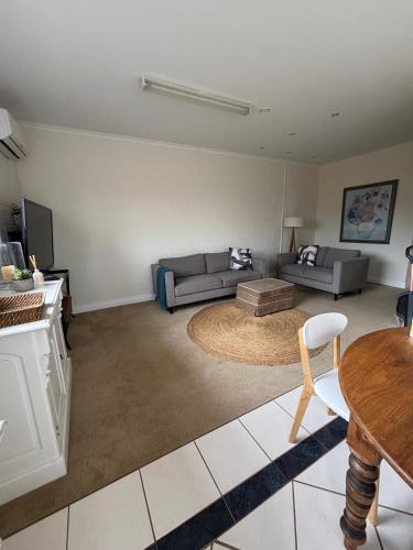 a living room with a couch and a table at Stay - East Wynyard Beach in Wynyard