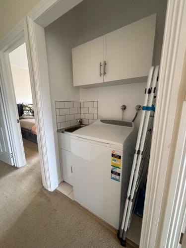 a small kitchen with a sink and a refrigerator at Stay - East Wynyard Beach in Wynyard