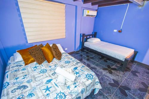 une chambre avec un lit avec un mur bleu dans l'établissement Posada Yeskol, à San Andrés