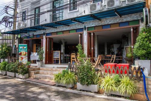a restaurant with plants in front of a building at Samed Big Tree in Ko Samed