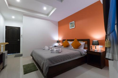 a bedroom with a bed with an orange wall at Samed Big Tree in Ko Samed