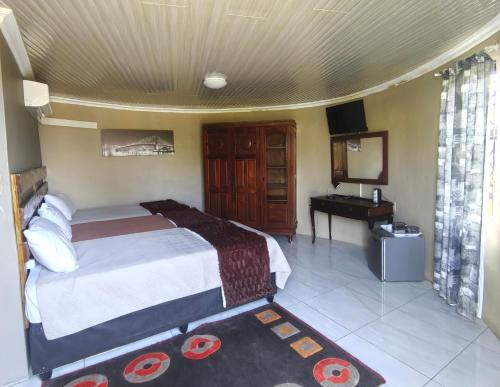 a bedroom with a bed and a desk in a room at Mbizana Lifestyle in Monzi