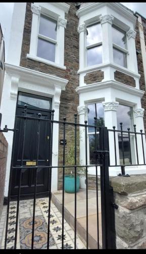a black gate in front of a house at Large newly refurbished house close to harbour Free Parking in Bristol
