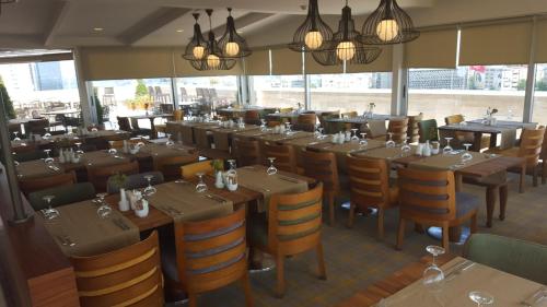 un ristorante con tavoli e sedie in una stanza con finestre di Taksim Gonen Hotel a Istanbul