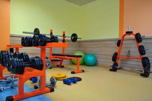a gym with dumbbells and weights in a room at Aqua Hotel in Burgas City