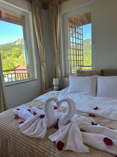 スモリャンにあるКъща за гости Падалотоの窓付きベッドの上に白鳥のタオル2枚