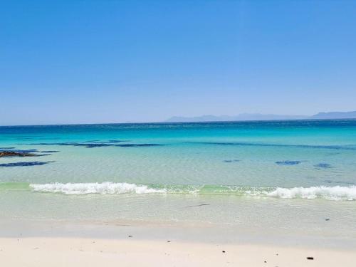 a beach with the ocean in the background at Romansbaai Beach House in Gansbaai