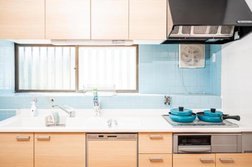 une cuisine avec un évier et un plan de travail dans l'établissement 宿 重富 Stay SHIGETOMI, à Aira