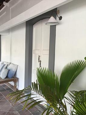 a front door of a house with a bench at Villa Helena in Puducherry