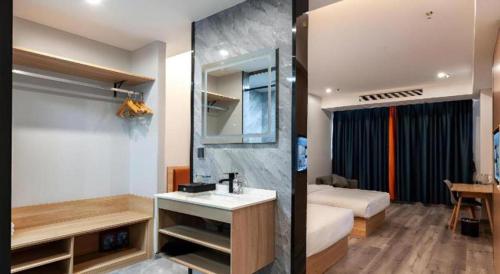 XiwujieqiaoにあるBorrman Hotel Jiangyin Zhouzhuangのバスルーム(シンク付)、ベッドルーム(ベッド1台付)