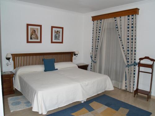 Un dormitorio con una cama con una almohada azul. en Caico's, en Prado del Rey