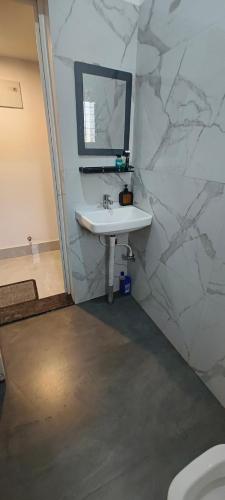 a white bathroom with a sink and a mirror at Hotel Purvanchal in Katihār