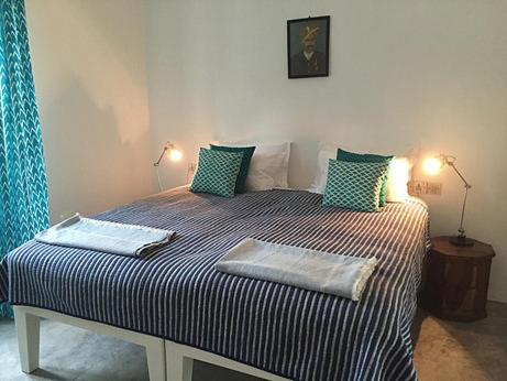 a bedroom with a large bed with two pillows at Villa Helena in Puducherry