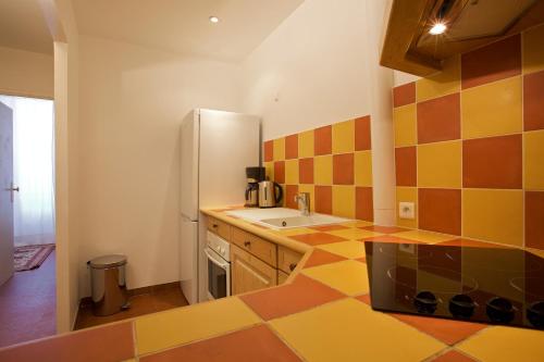 uma cozinha com pisos em azulejo coloridos e um frigorífico em 15 Cours Massena em Antibes