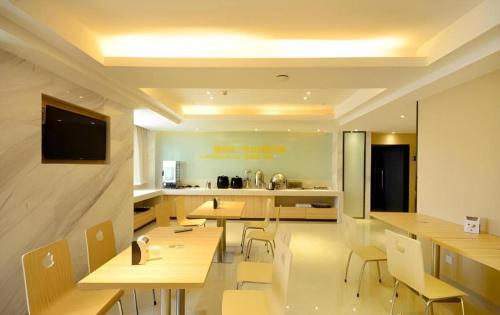 un restaurant avec des tables et des chaises en bois et une cuisine dans l'établissement City Comfort Inn Wuhan Wangjiawan Sixin Avenue Metro Station, à Wuhan