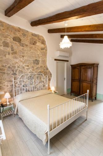a bedroom with a bed and a stone wall at Aia Antica in Monte San Biagio