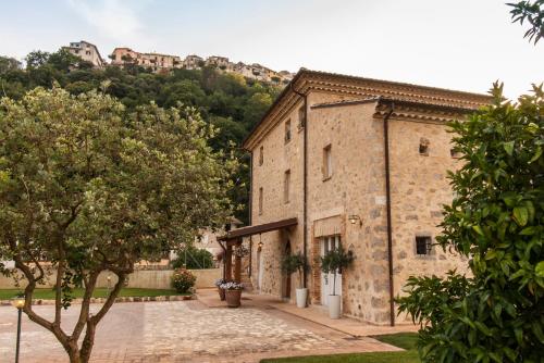 a large stone building with a hill in the background at Aia Antica in Monte San Biagio