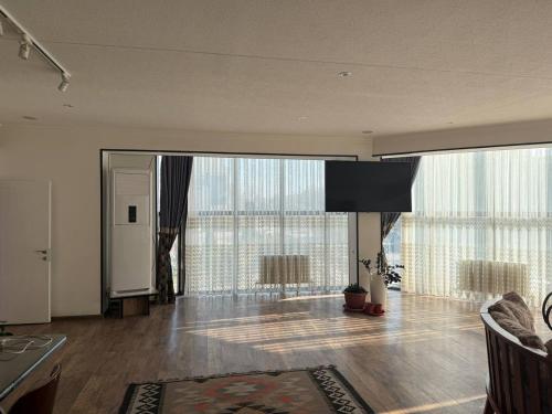 a living room with a large room with glass windows at Manija Hostel in Samarkand