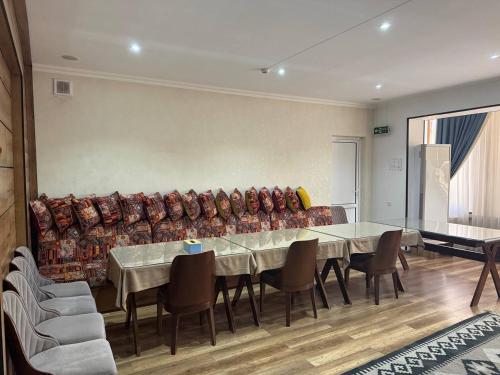 a dining room with a couch and a table and chairs at Manija Hostel in Samarkand