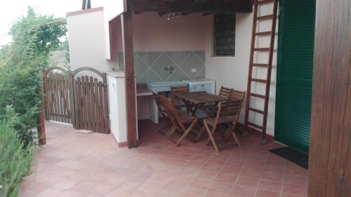 a patio with a table and chairs and a ladder at Agriturismo Collelungo di Maremma in Diaccialone