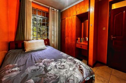 a bedroom with a bed with a painting of roses at Majestic Two-bedroom House in a prime location in Nairobi