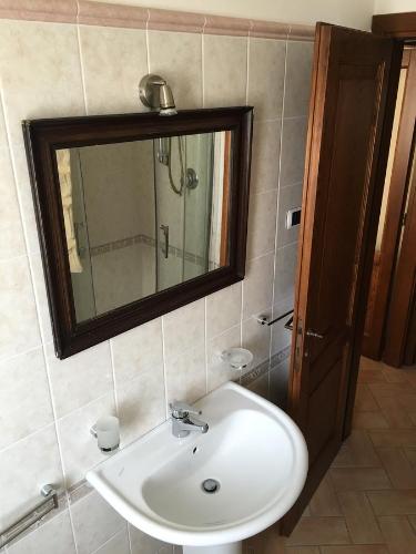 bagno con lavandino bianco e specchio di Alle Porte di Assisi ad Assisi