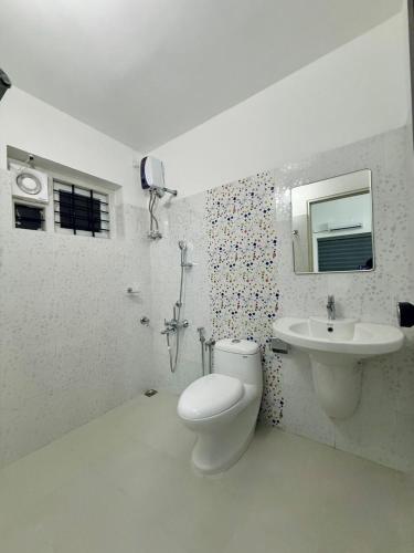 a bathroom with a toilet and a sink at Zenaura Casa Villa 2 in Cochin